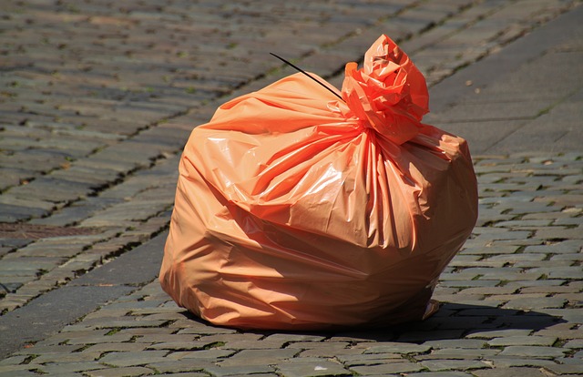 Imagen de una bolsa de basura color naranja sobre una calle